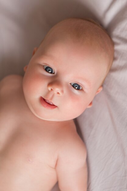 Photo happy baby girl lying on bed