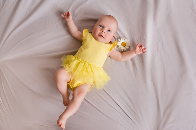 Happy baby girl lying on bed