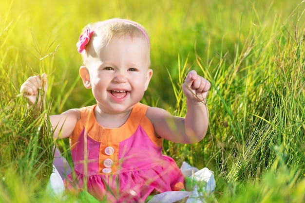 Happy baby girl on meadow on the nature