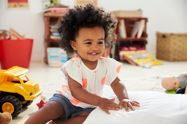 Happy Baby Girl Playing With Toys In Playroom