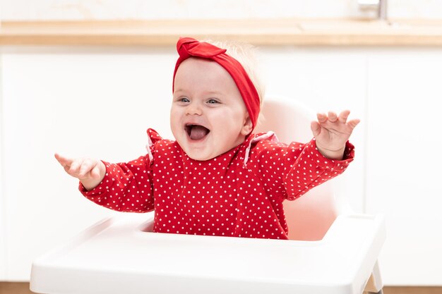 Photo happy baby girl sitting in high chair