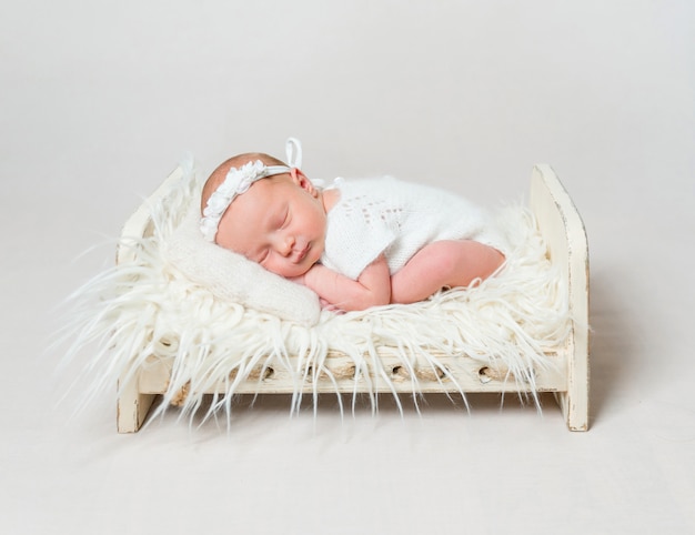 Happy baby girl sleeping on small crib