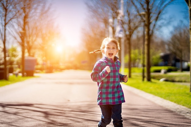 Happy baby girl smiling little girl running at sunset cute baby girl running at playground garden Happy family baby girl