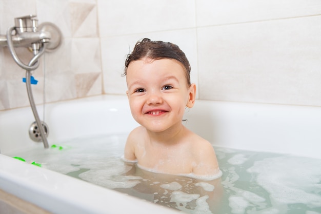 Happy baby having a bath .