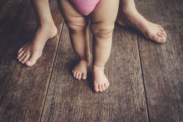 happy baby learning to walk with mother help