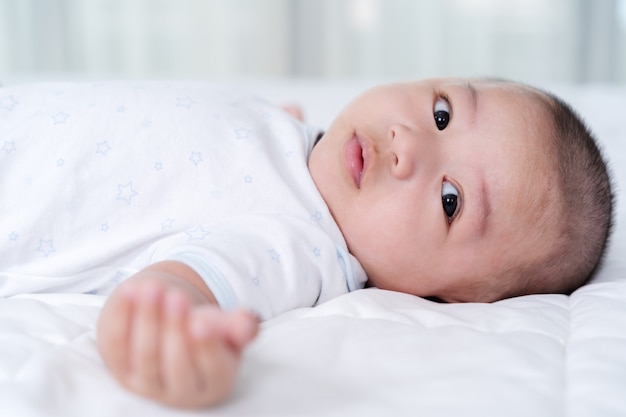 Happy baby liggend op een bed