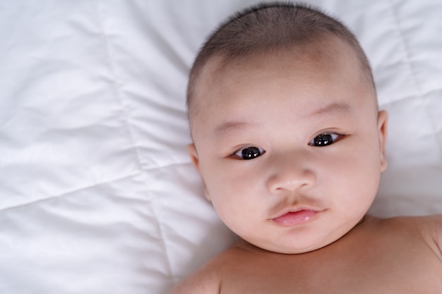 Happy baby lying on a bed