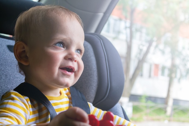 Foto felice baby sitter nel seggiolino auto che gioca