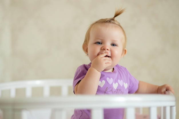 happy baby sitting at the table in the kitchen and eating with an appetite