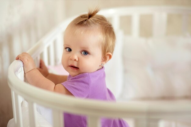 happy baby sitting at the table in the kitchen and eating with an appetite