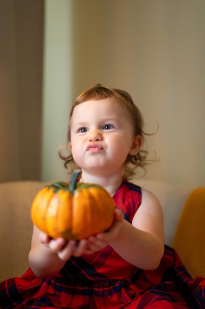 Photo happy baby with a pumpkin for halloween home