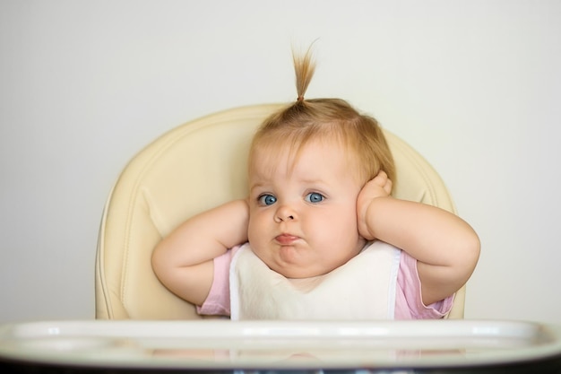 happy baby zit op een stoel en maakt zich klaar om te eten