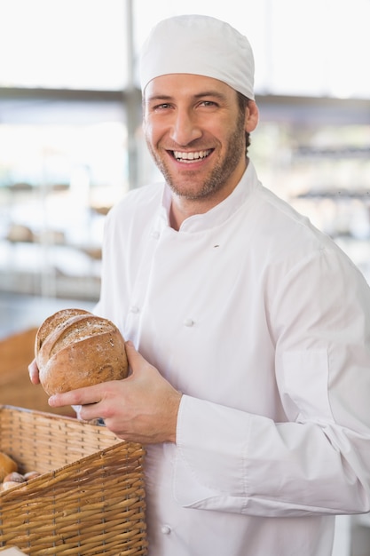 Happy baker with loaf of bread