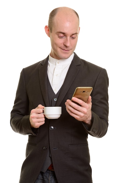 Happy bald Caucasian businessman smiling while holding mobile phone