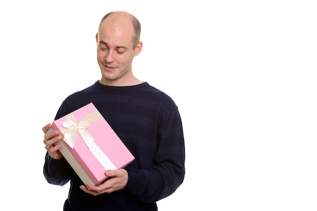 Happy bald Caucasian man smiling while holding and looking at gi