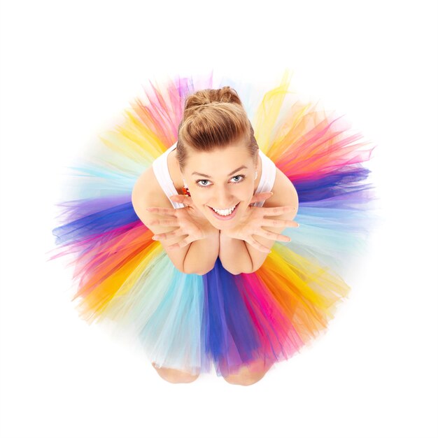 a happy ballerina posing in a colourful skirt over white background