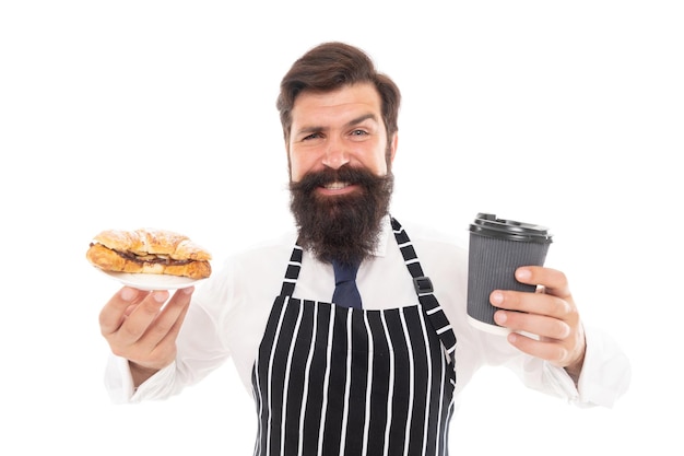 흰색 카페에 격리된 구운 디저트와 함께 테이크아웃 커피나 차를 제공하는 행복한 바리스타 남자.
