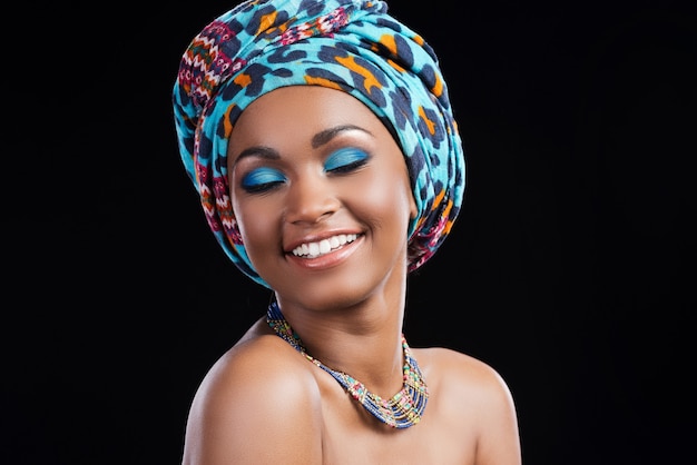 happy to be herself. happy young african woman wearing a headscarf and necklace 