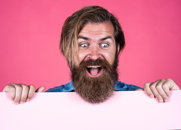 Happy bearded brutal man with moustache hold paper shit for copy space business