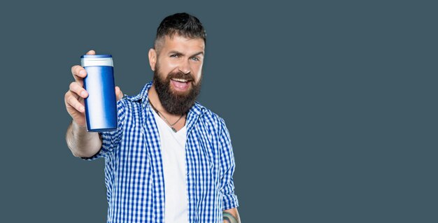 happy bearded guy hold male product of beard care cosmetics