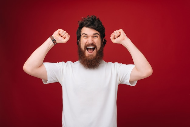 Счастливый бородатый мужчина активно жестикулирует, выражает положительные эмоции. концепция языка счастья и тела