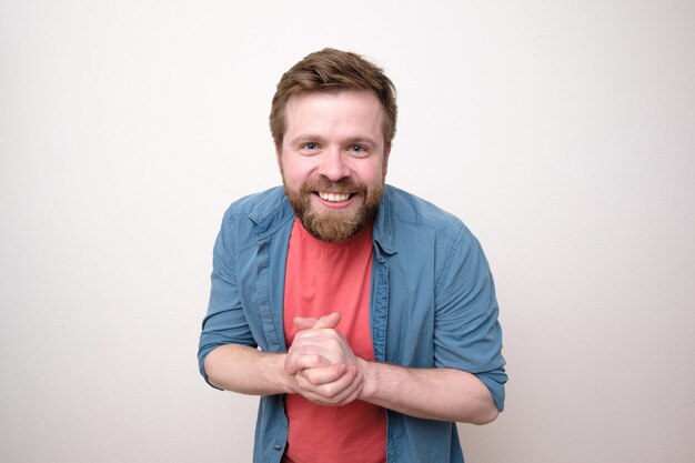 Happy bearded man in casual clothes smiling and looking friendly