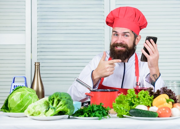 Happy bearded man chef recipe Dieting organic food Vegetarian salad with fresh vegetables Cuisine culinary Vitamin Healthy food cooking Mature hipster with beard Shopping online is so easy