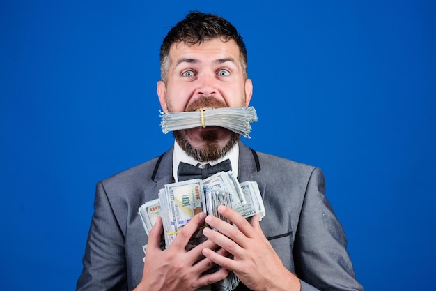 Happy bearded man has a lot of money Business and sport success winning a lottery businessman after great deal Finance and commerce Billioner with dollar banknotes Pocketing company money