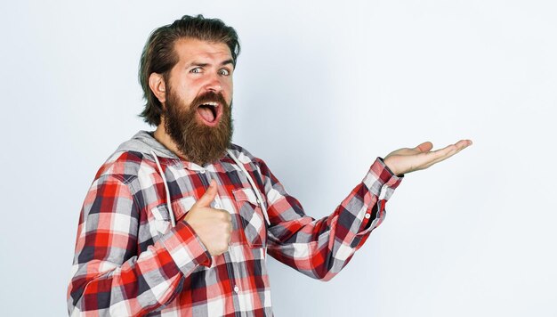 Happy bearded man holds something on open hand palm and showing thumb up season sale and discount