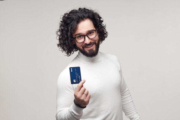 Photo happy bearded man promoting bank card in studio