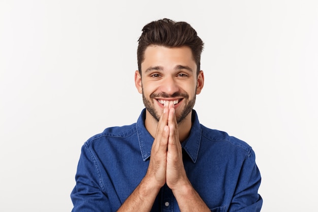 Felice uomo barbuto in camicia che mostra pregare gesto e cercare isolato grigio