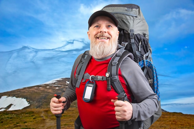 사진 산의 풍경을 배경으로 하이킹 장비를 가진 행복한 수염 남성 여행자
