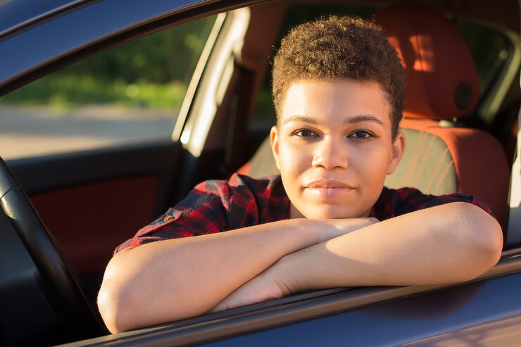 車の中で短い髪、ライフスタイルを持つ幸せで美しいアフリカ系アメリカ人の女性。