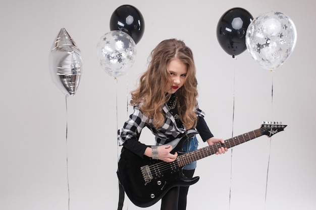 Happy beautiful artistic small girl playing guitar 