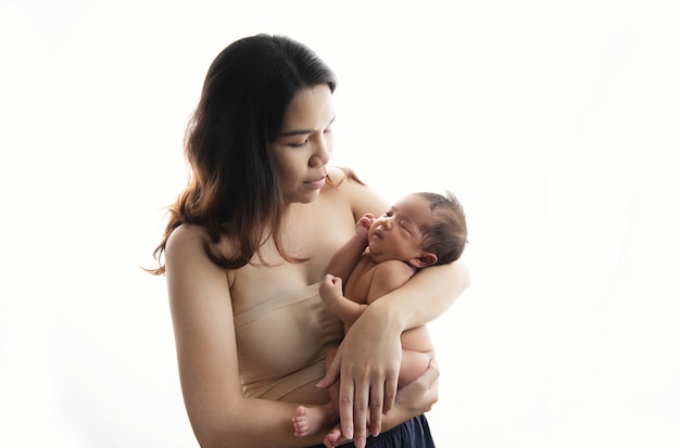 Happy beautiful asia woman black long hair looking at her sleeping baby child in arm. love from mother to son or daughter family concept.