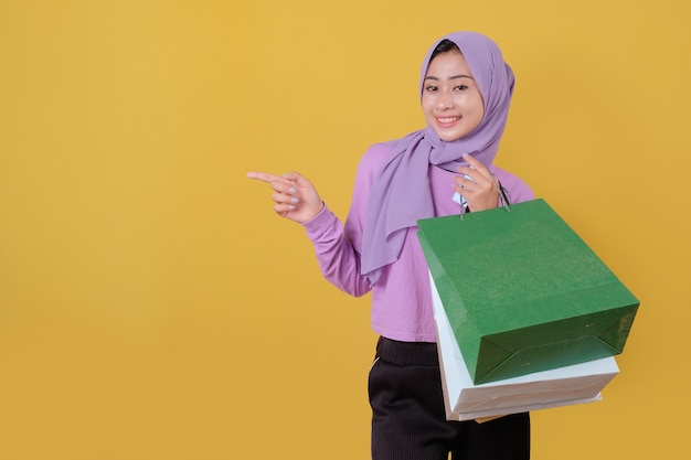 Happy beautiful asian shopaholic women holding shopping bags