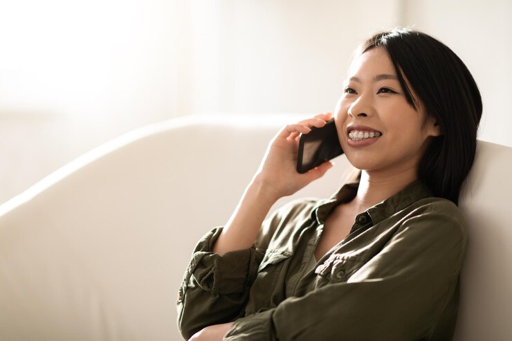 Photo 自宅で電話で会話をしている幸せな美しいアジアの女性