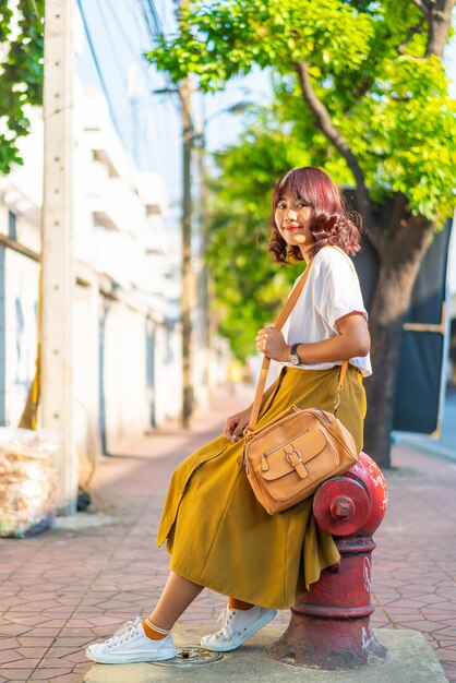 幸せで美しいアジアの女性がタイのカオサーンロードを旅行