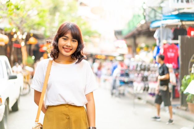 幸せで美しいアジアの女性がタイのカオサーンロードを旅行