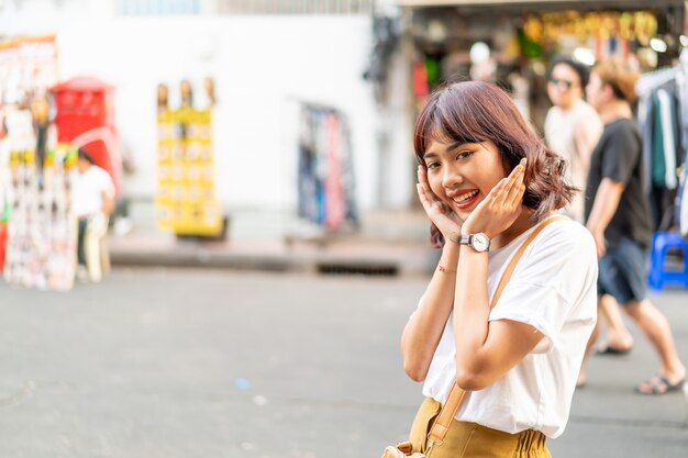 タイのカオサーンロードを旅行して幸せで美しいアジアの女性