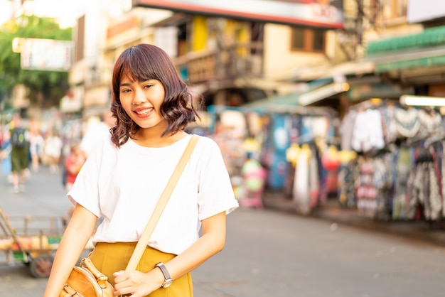 Счастливая и красивая азиатская женщина путешествуя на Khao Sarn Road, Таиланде