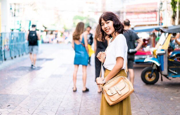 Donna asiatica felice e bella che viaggia a khao sarn road, tailandia