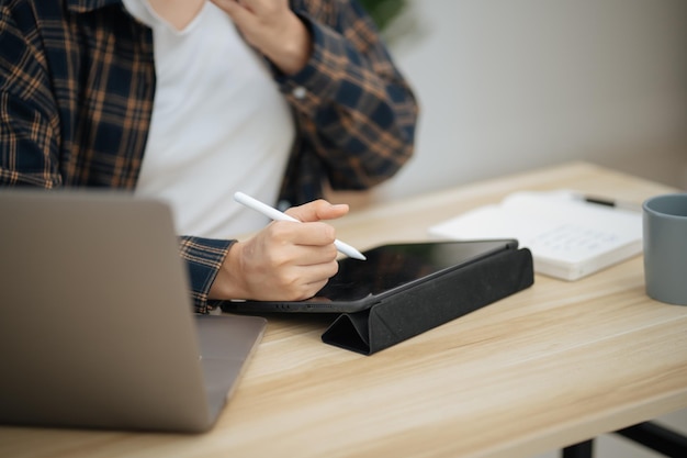 Happy beautiful Asian woman using computer laptop for work online at living room