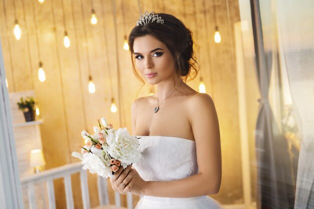 Happy and beautiful bride with bouquet of flowers