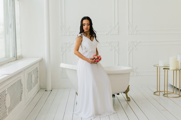 Happy beautiful bride with her veil smiling and excited in an interior, wedding morning