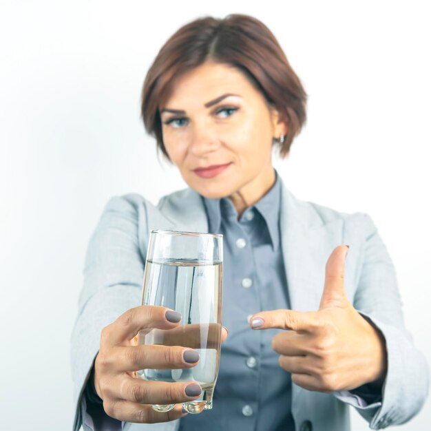 Happy beautiful business woman offers a glass of water Thirst and health