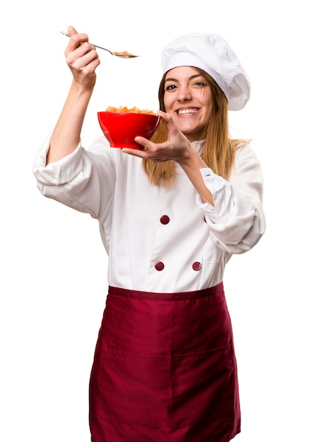 그릇에서 시리얼을 먹는 행복 한 아름 다운 요리사 여자