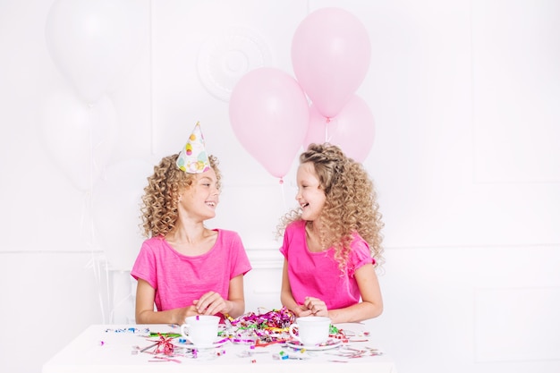 Felici bei bambini carini sorridono alla festa con palloncini e coriandoli insieme