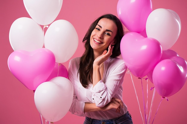 Happy beautiful cute lovely woman with colorful balloons and gift in hands is have a fun and celebration. Birthday, Holidays, St Valentines day and other