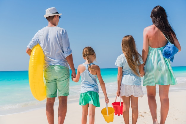 Happy beautiful family on white beach having fun